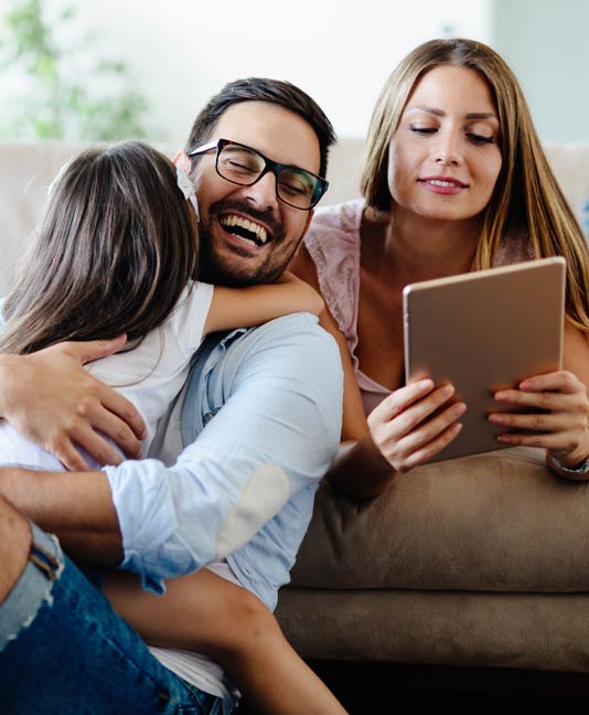 Family smiling and on tablet