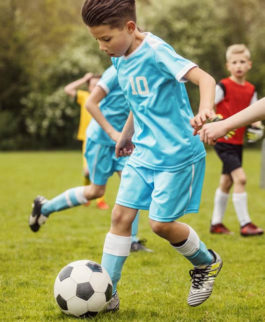 Kid wearing mouthguard playing soccer
