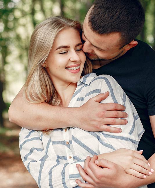 Young woman with braces embracing partner